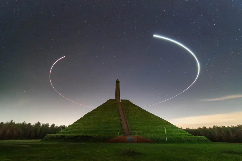 Lichtspoor van een drone in een cirkel rond de Pyramide van Austerlitz onder de sterren
