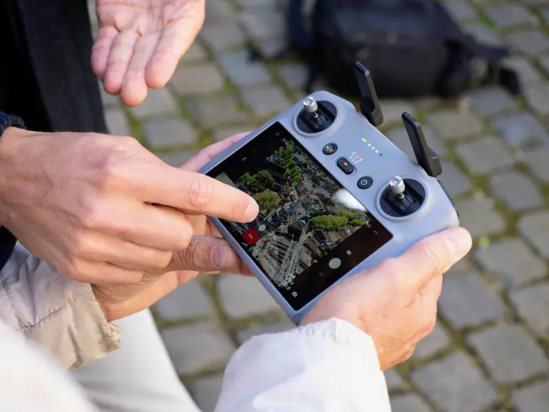 DJI-controller met live beeld van de binnenstad, de docent wijst een instelling aan