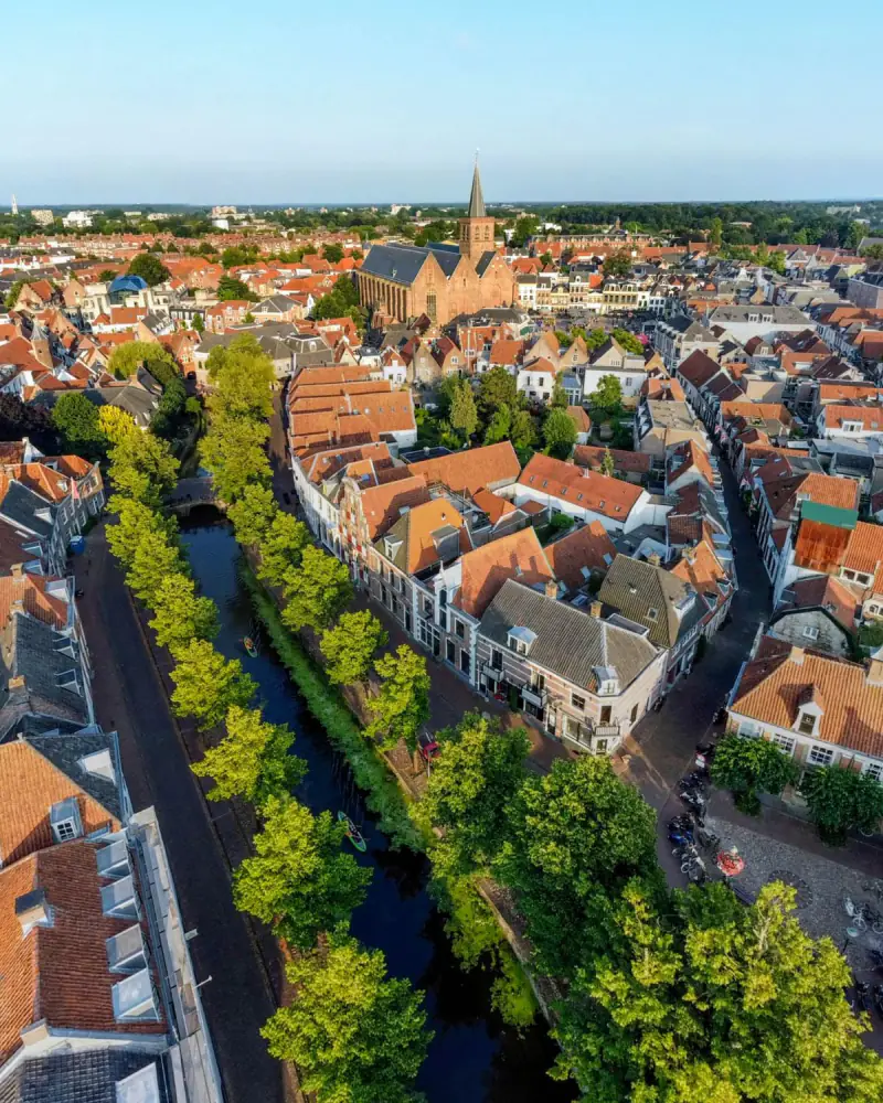 De Sint-Joriskerk en de binnenstad van Amersfoort met de bomen langs de gracht, vanuit de drone