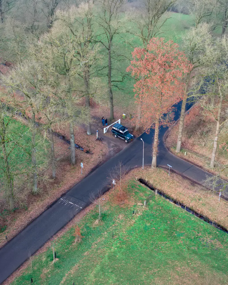 Land Rover en deelnemers op een kruising van boslanen bij Den Treek in Leusden, vanuit de drone
