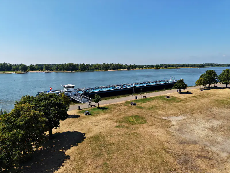 De rivier bij Gorinchem met binnenvaartschepen aan de kade, vanuit de drone
