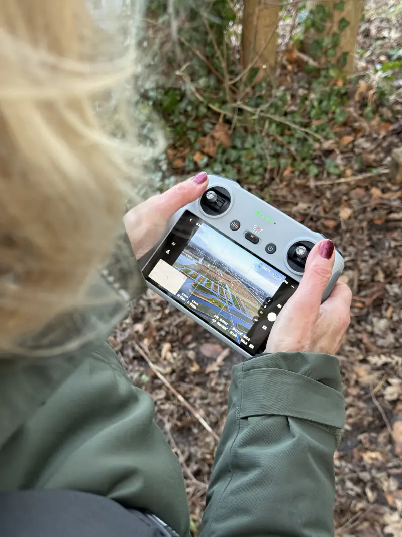 Deelnemer met de DJI-controller bij Heerhugowaard; op het scherm de polder van boven