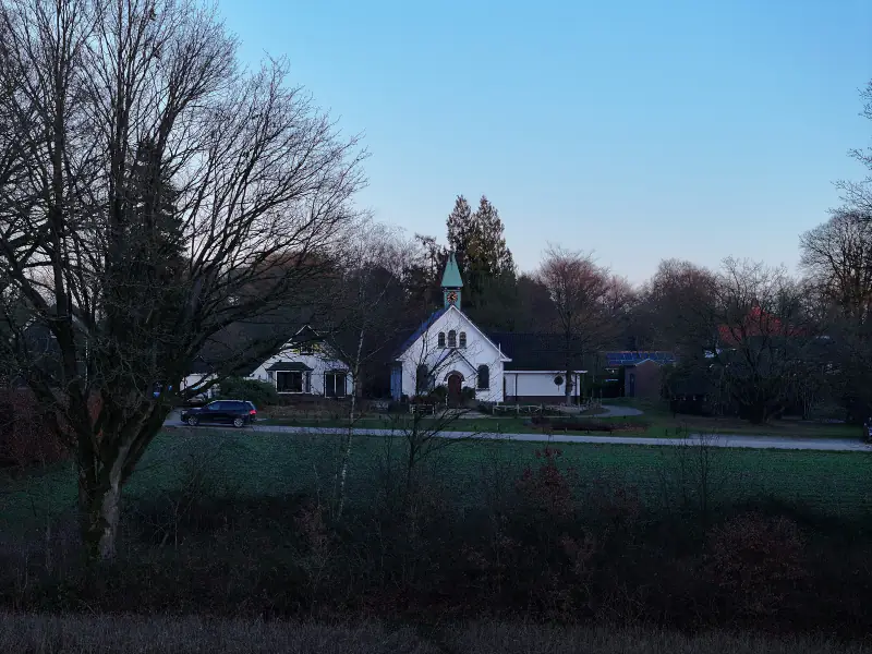 Het witte kerkje van Hoog Soeren in het blauwe uur, vanuit de drone