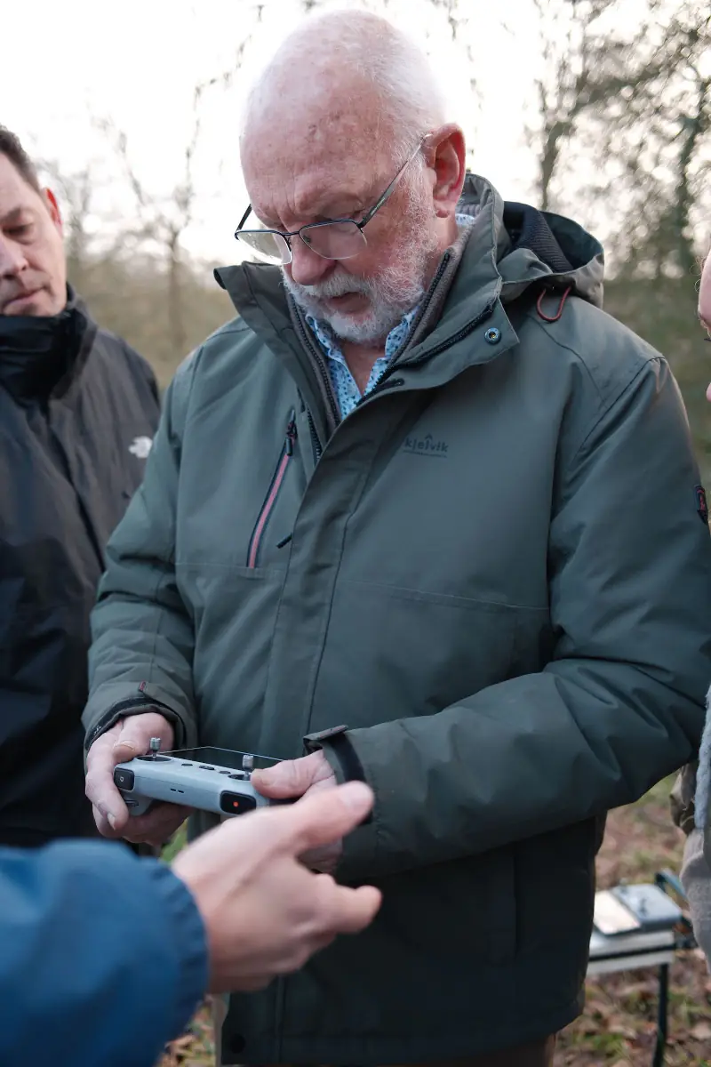 Opa kijkt naar het scherm van de controller terwijl ik iets aanwijs
