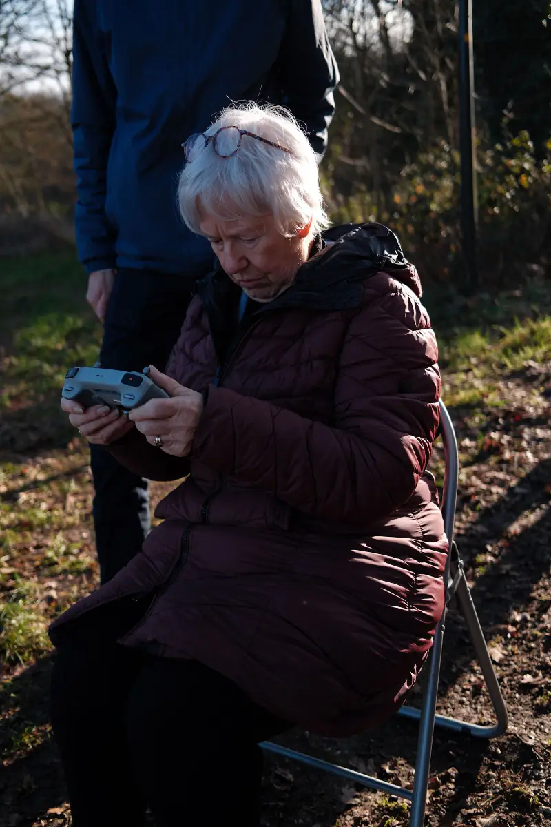 Een deelnemer zit geconcentreerd met de controller op een krukje