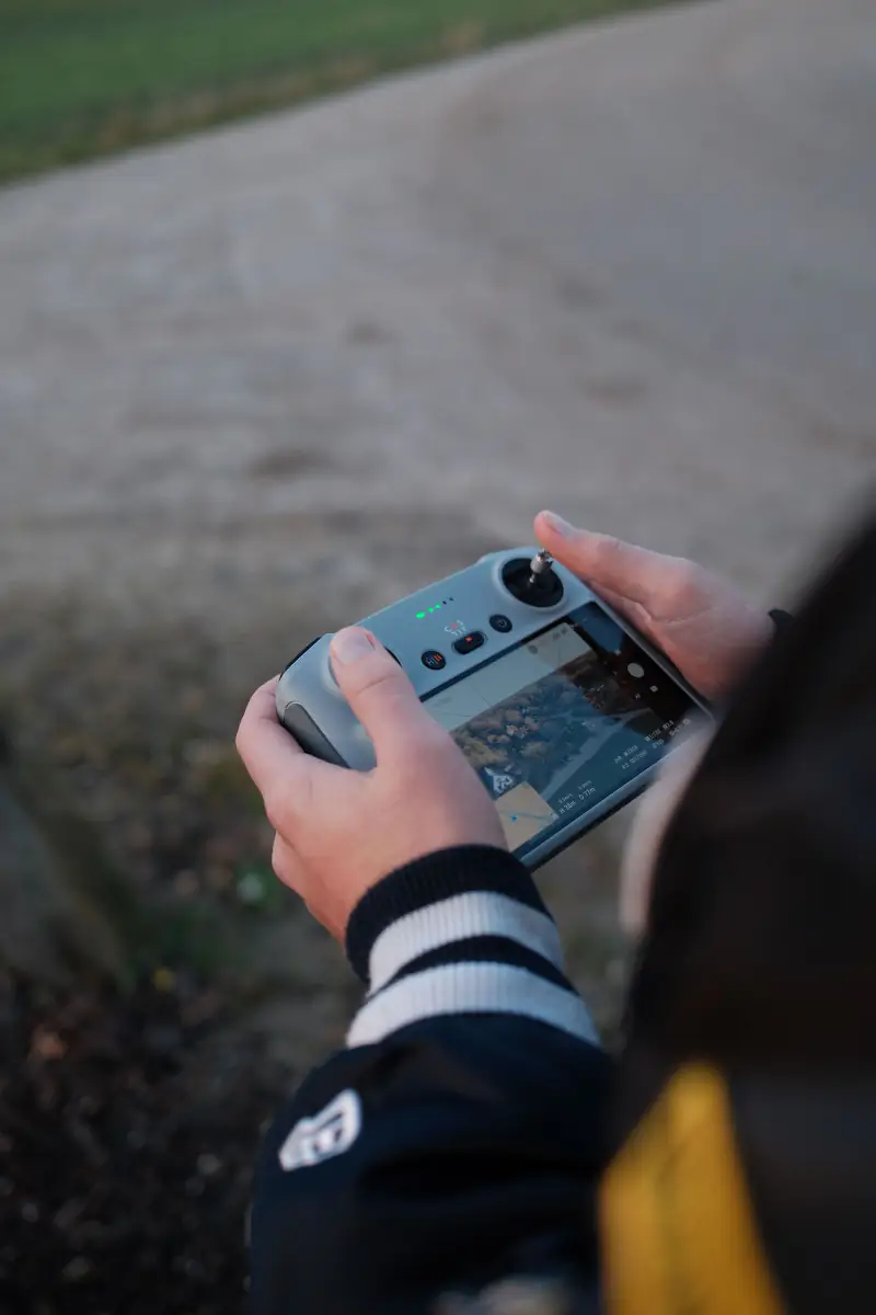 Handen om de controller, het beeld van de drone op het scherm