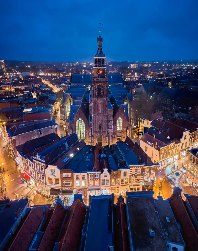 De binnenstad van Gouda met de langste kerk van Nederland, in de avond vanuit de lucht