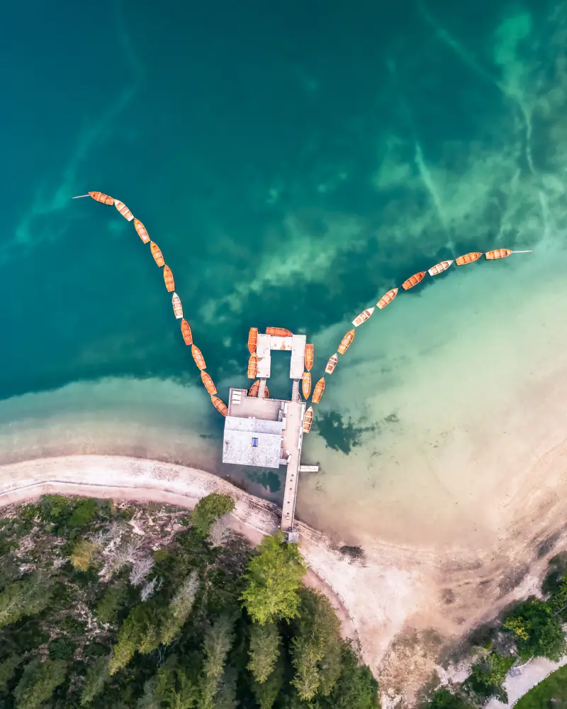 Boten in een lijn bij het Lago di Braies in de Dolomieten, recht van boven