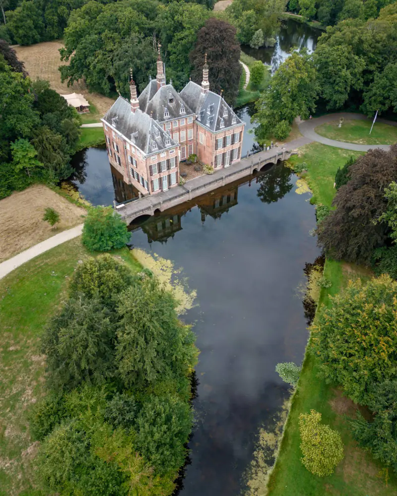 Kasteel Duivenvoorde in Voorschoten met slotgracht en stenen brug, vanuit de drone