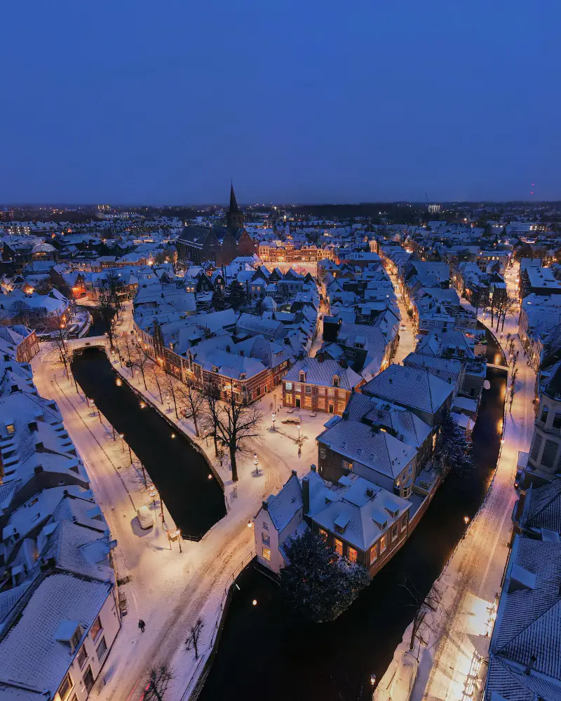 De besneeuwde binnenstad van Amersfoort in het blauwe uur, vanuit de lucht