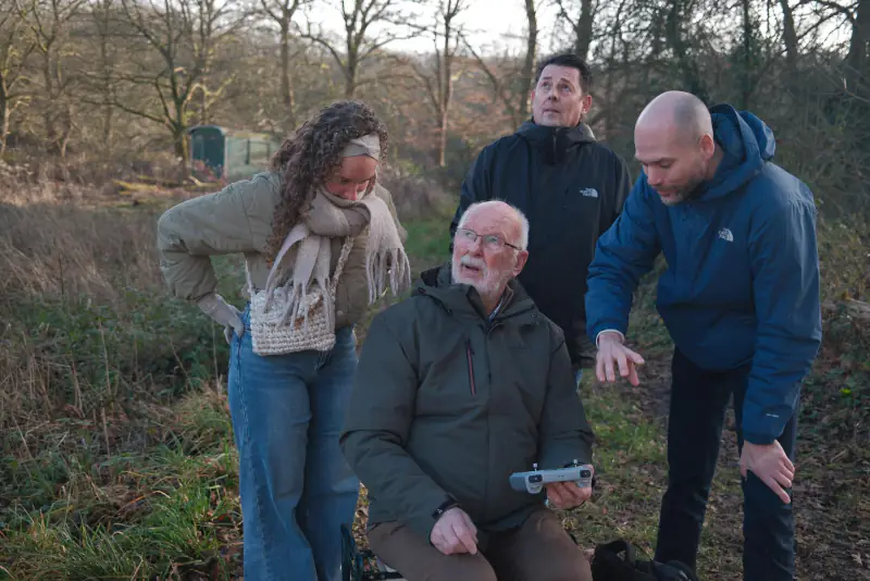 Familie kijkt mee terwijl opa de drone bestuurt (foto: Jytte Bekkers, Hoog Soeren)